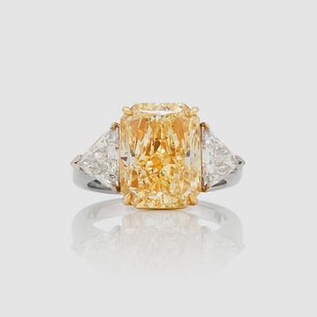 1188. A fancy yellow diamond, 8.01 ct, FY/SI2, flanked by triangular cut diamonds, 1.62 cts in total, ring.