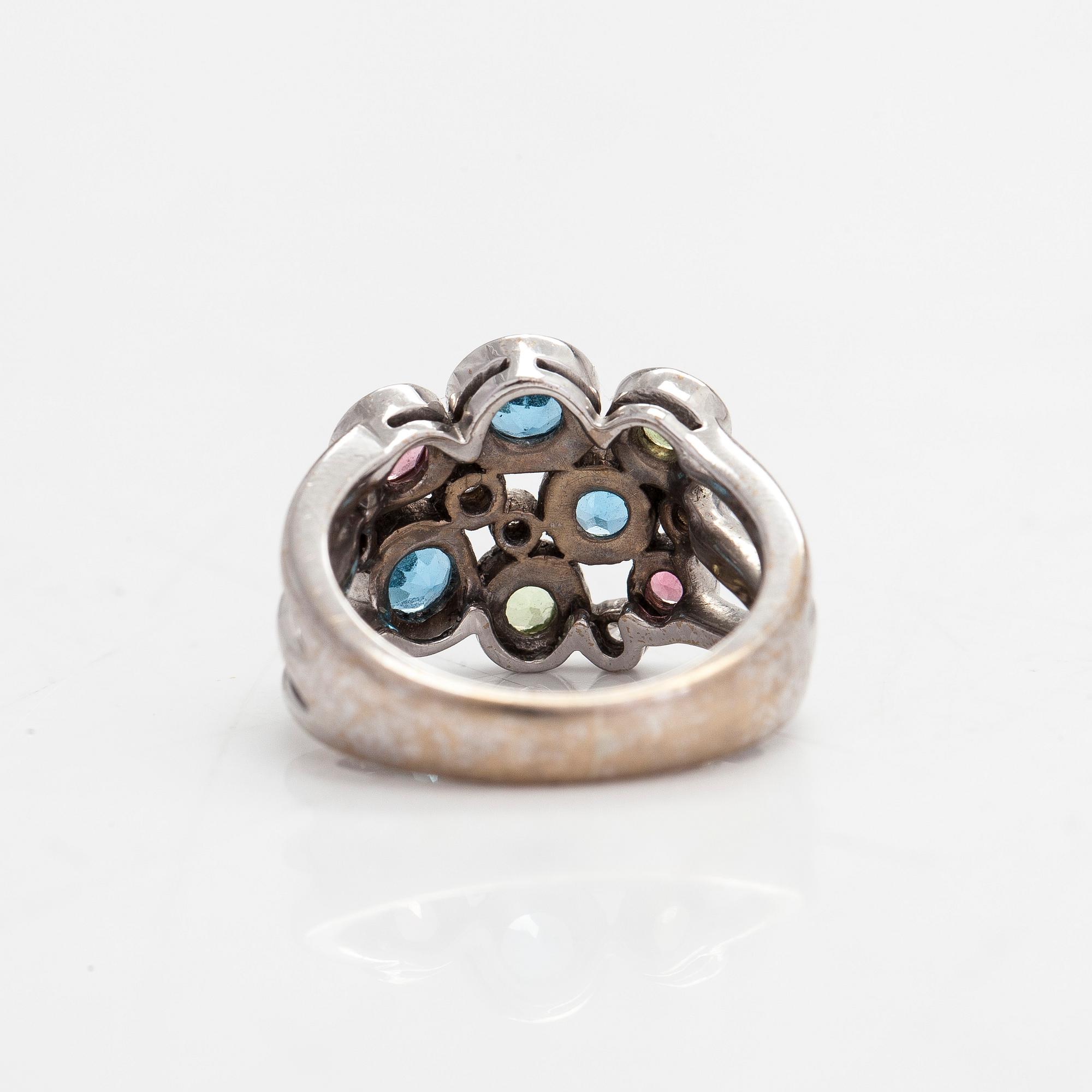 Cassandra Goad, sormus, "Cirkel", 18K valkokultaa, timantteja noin 0.08 ct ja monivärisiä jalokiviä. Lontoo.