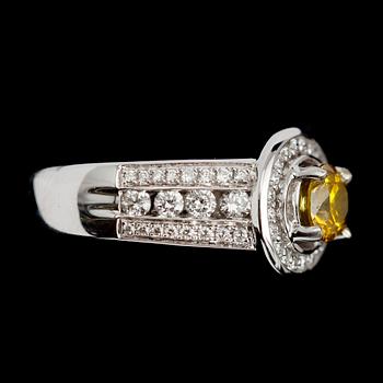 RING, 14 k vitguld, gul solitär briljantslipad diamant 0.84 ct samt mindre briljantslipade diamanter tot ca 1.0 ct.