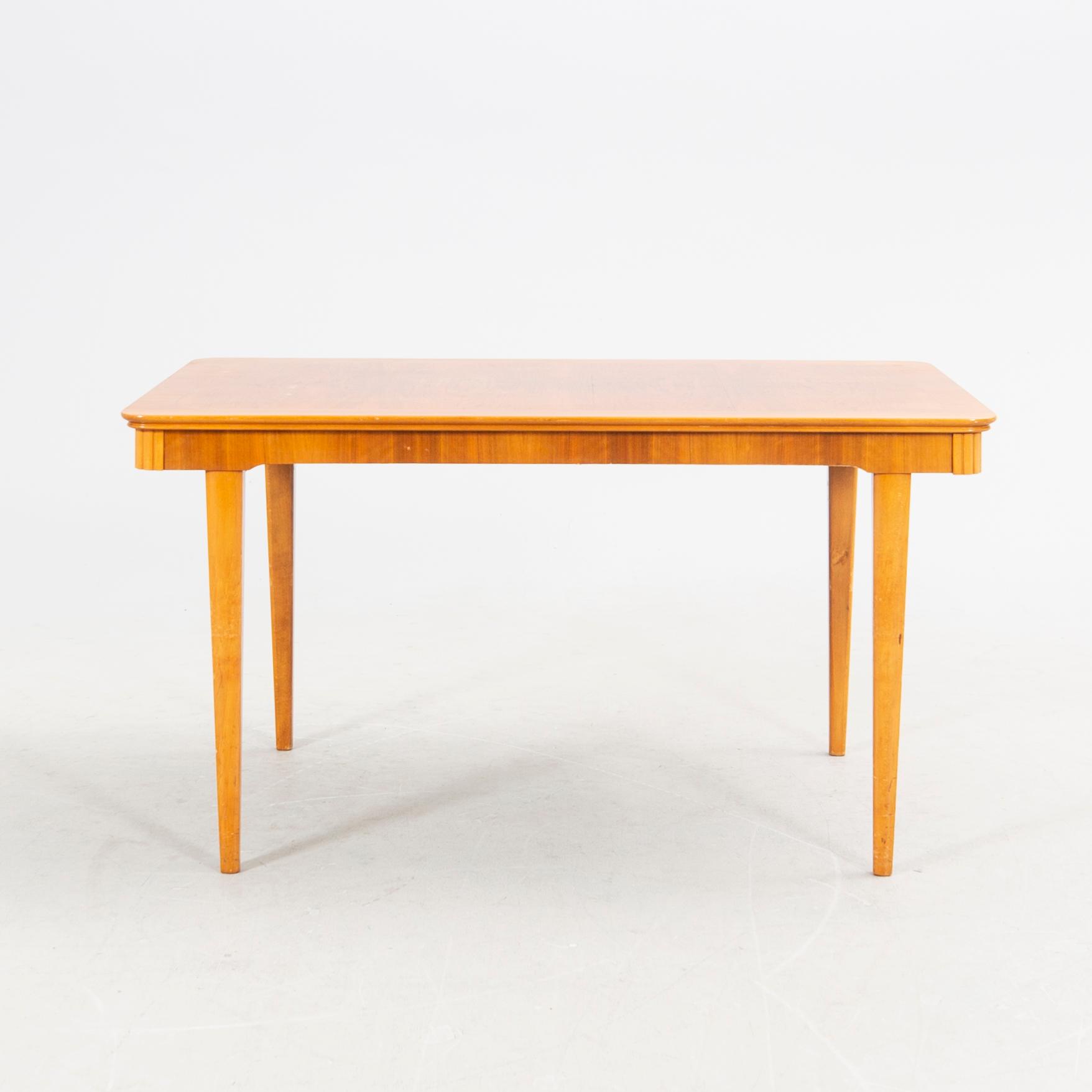 A 1940s mahogany and walnut dining table.