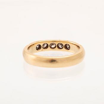 An 18K gold half-eternity ring set with round brilliant-cut diamonds.