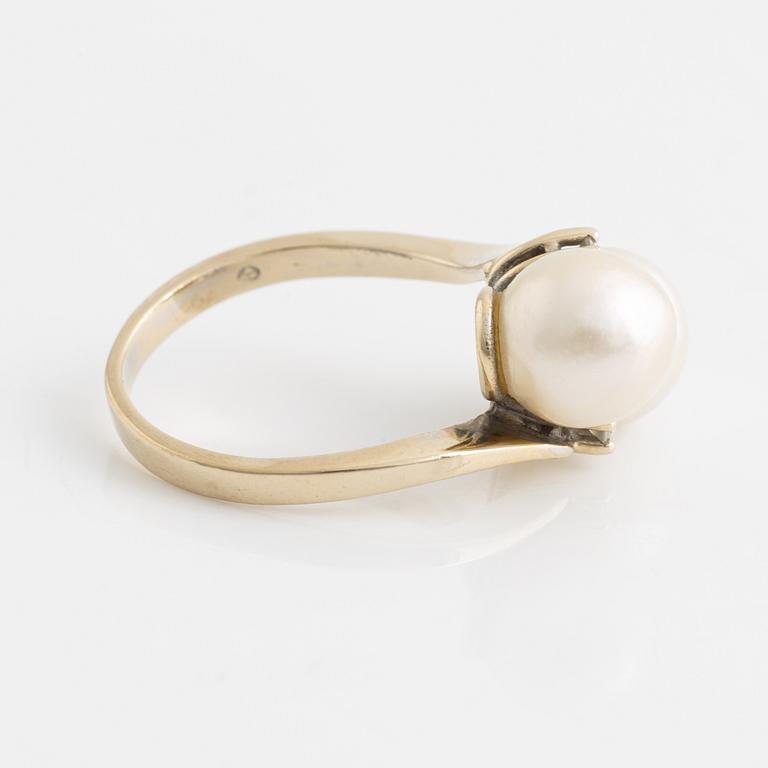An 18K gold ring set with cultured pearls and white stones.
