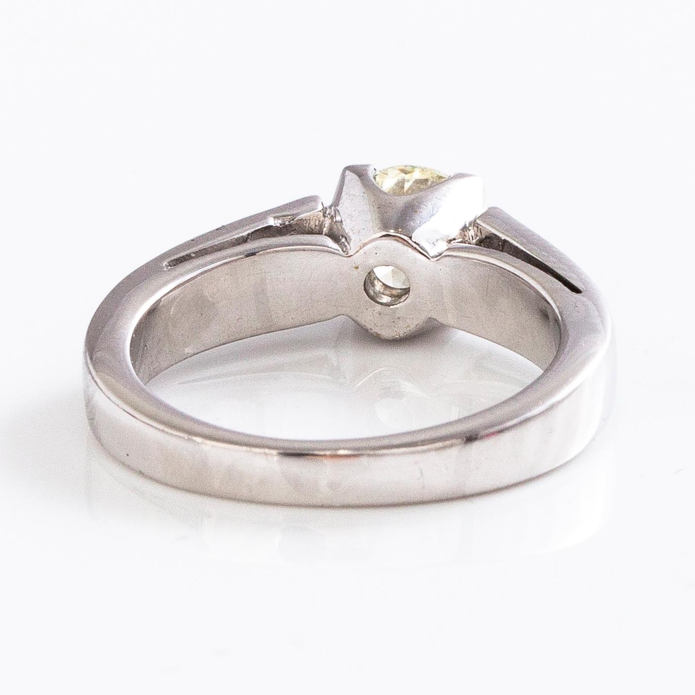 An 18K gold ring with a brilliant-cut diamond ca. 1 ct and princess-cut diamonds ca. 0.7 ct in total.