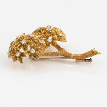 An 18K gold brooch set with round brilliant-cut diamonds.