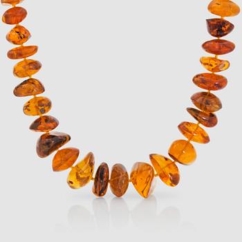 A single-strand Dominican amber necklace of 47 graduated amber beads filled with different kinds of insects.
