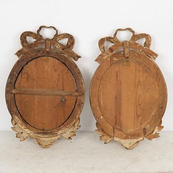 A Gustavian one-branch giltwood girandole mirror (with an associated copy), Stockholm, late 18th century.