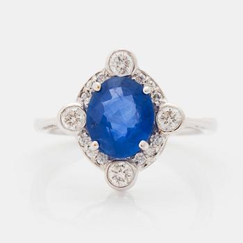 522. An 18K white gold ring set with a faceted sapphire and round brilliant-cut diamonds.