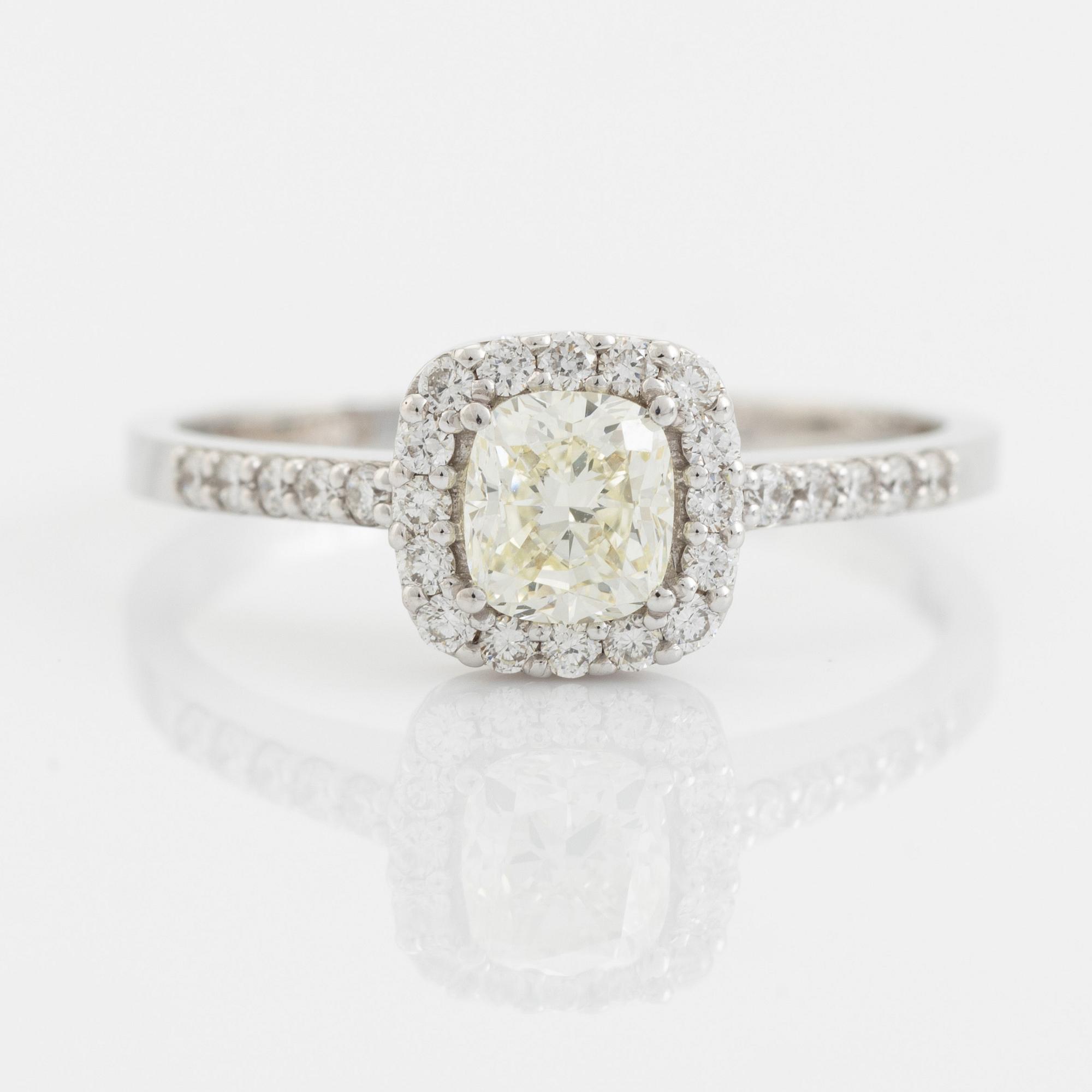 Ring med cushionslipad diamant och briljantslipade diamanter.