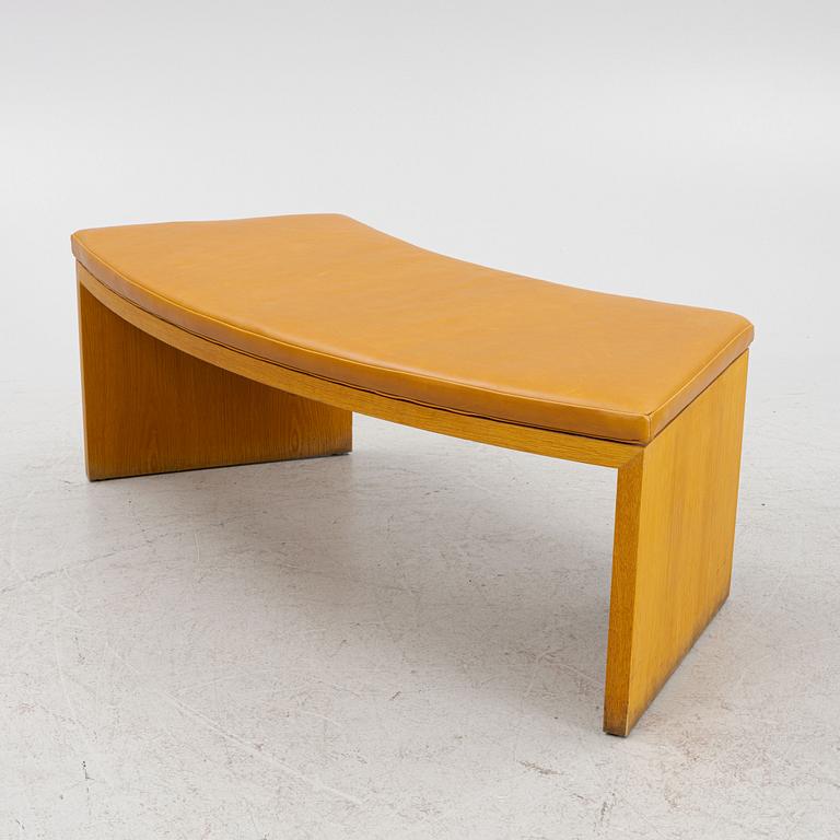 A 21st Century oak bench with leather seating.