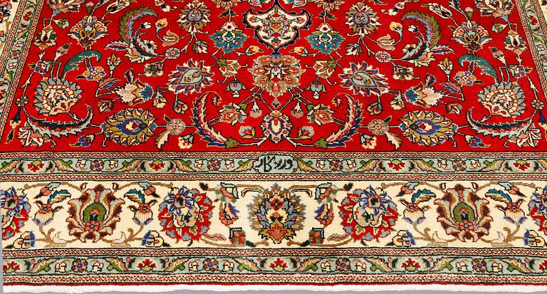 A signed Tabriz carpet, ca 336 x 223 cm.