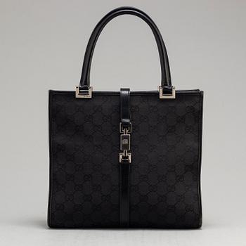 GUCCI, a leather and canvas bag.