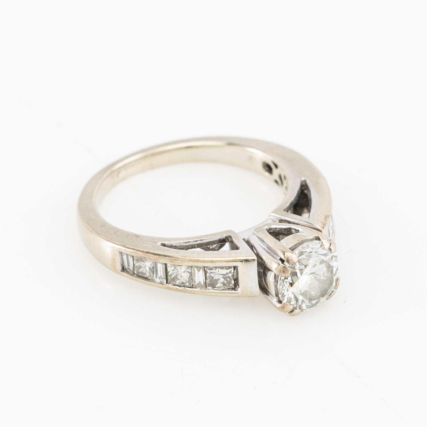 Ring 14K white gold set with a round brilliant-cut diamond, as well as princess-cut and baguette-cut diamonds.