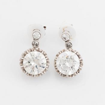 A pair of platinum earrings set with round brilliant- and old-cut diamonds.