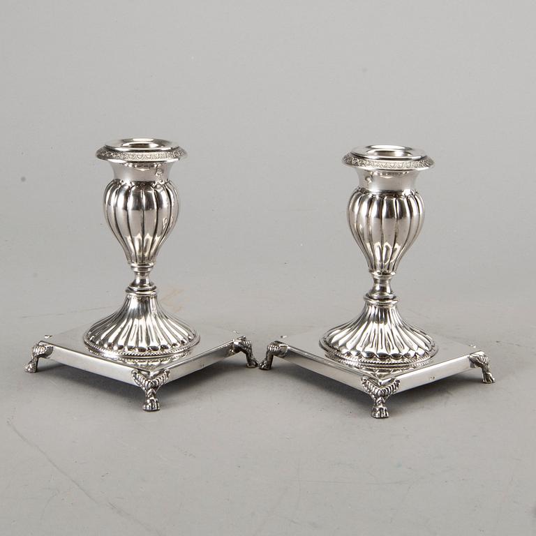 A silver bowl on foot, a pair of candlesticks and a spoon. early 20th century. Total weight app. 800 gram.