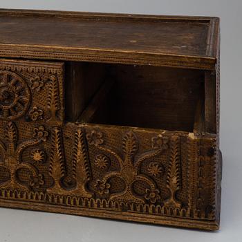 A 19th century wooden box with drawers.