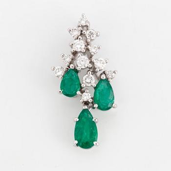 An 18K white gold emerald and diamond pendant.