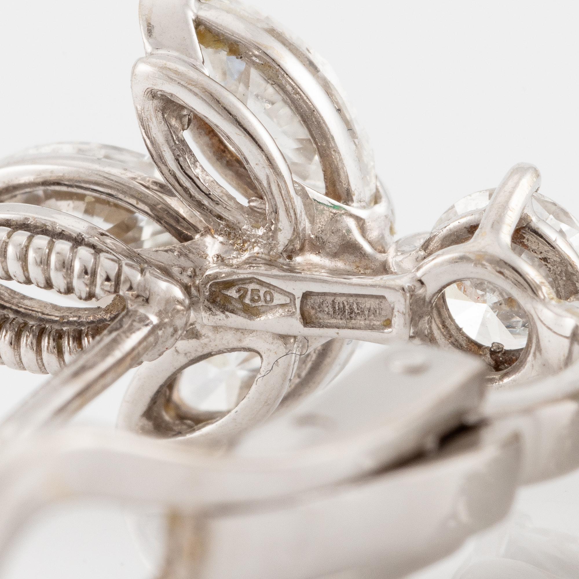 A pair of earrings in 18K white gold with drop-shaped faceted emeralds and diamonds.