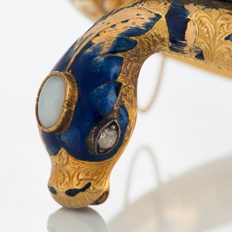 An 18K gold snake bangle decorated with blue enamel and set with an opal and a rose-cut diamond.