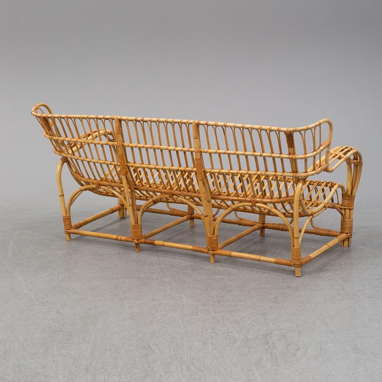 A rattan and glass table and a rattan sofa, second half of the 20th century.