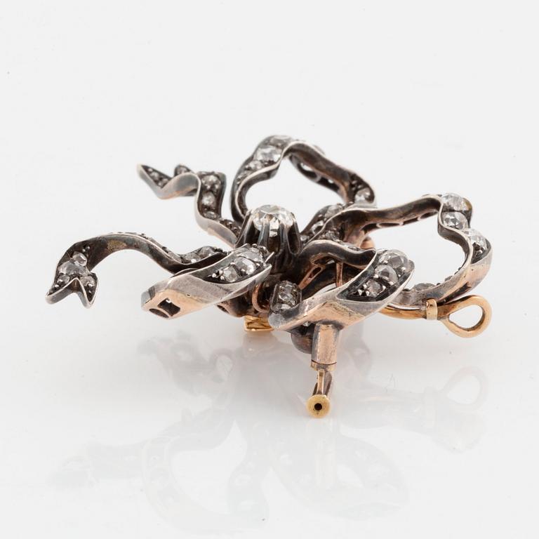 A silver and 14K gold bow brooch/pendant set with old- and rose-cut diamonds.
