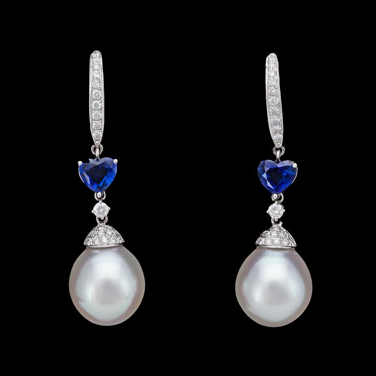 A pair of cultured South sea pearl, 12,2 mm, blue sapphire and brilliant cut diamond earrings, tot. app. 0.50 cts.