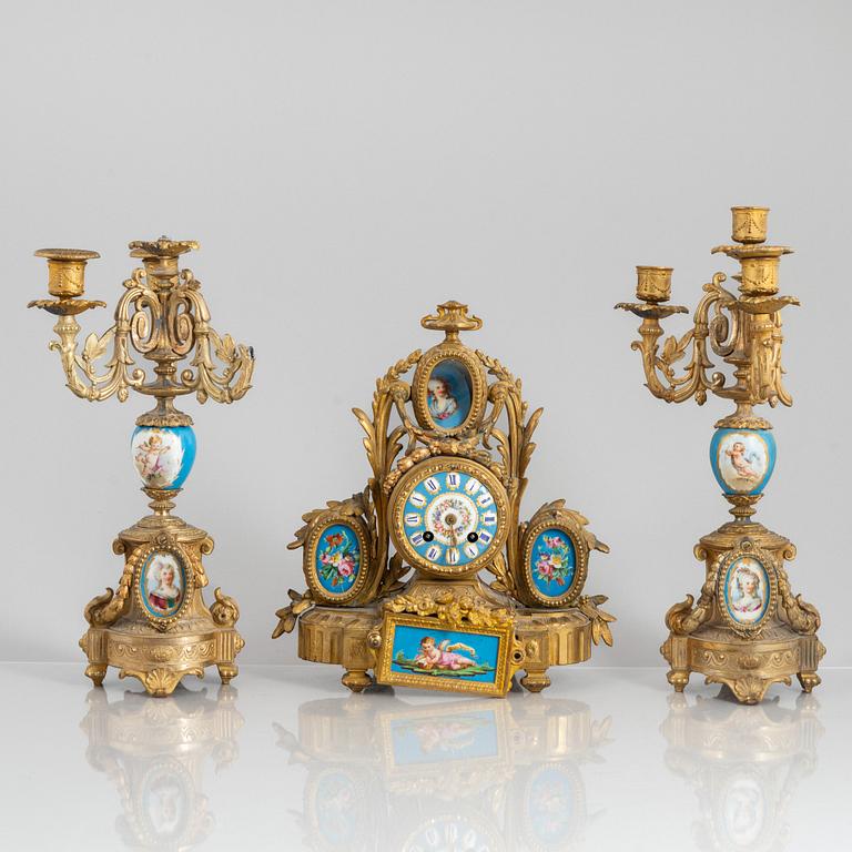 A Louis XVI style mantel clock and a pair of candelabra, circa 1900.