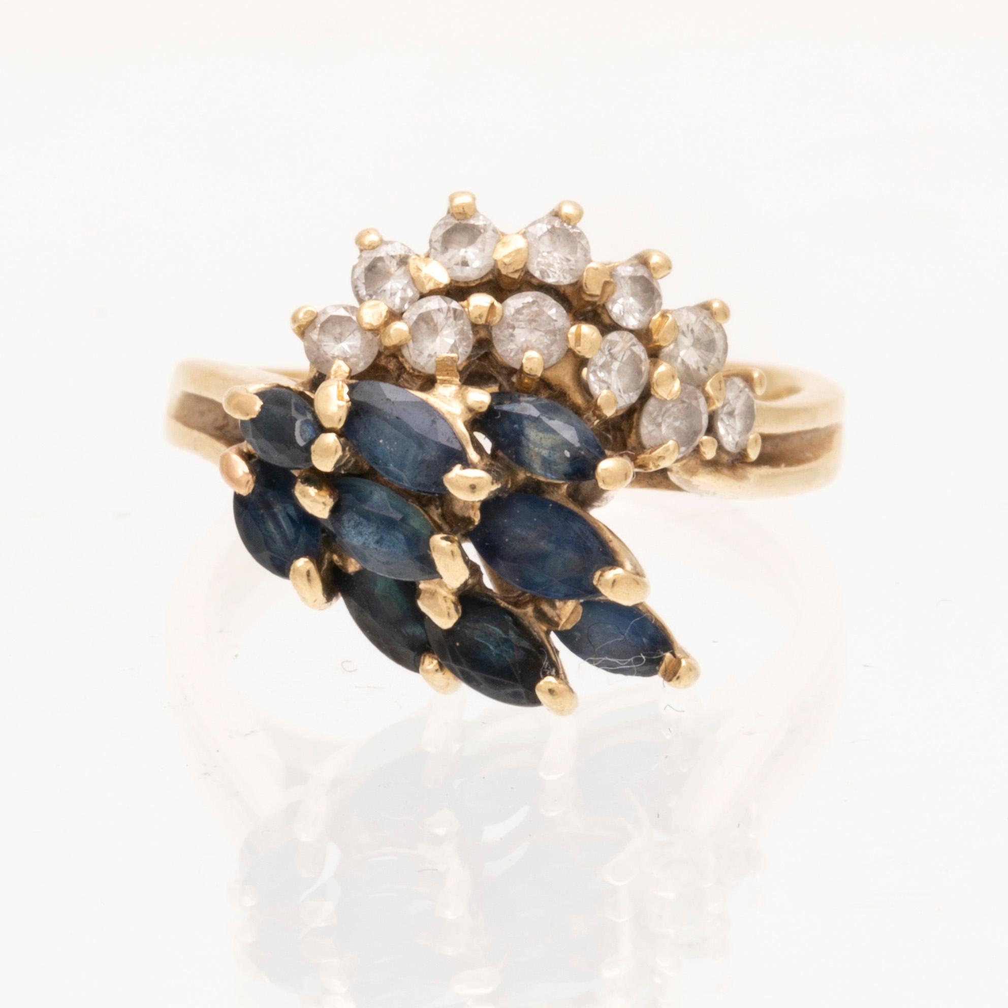 An 18K gold ring with marquise cut sapphires and round brilliant cut diamonds.