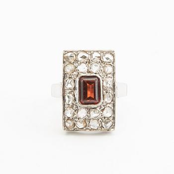Ring, 18K vitguld med röd sten (möjligen granat) och diamanter.