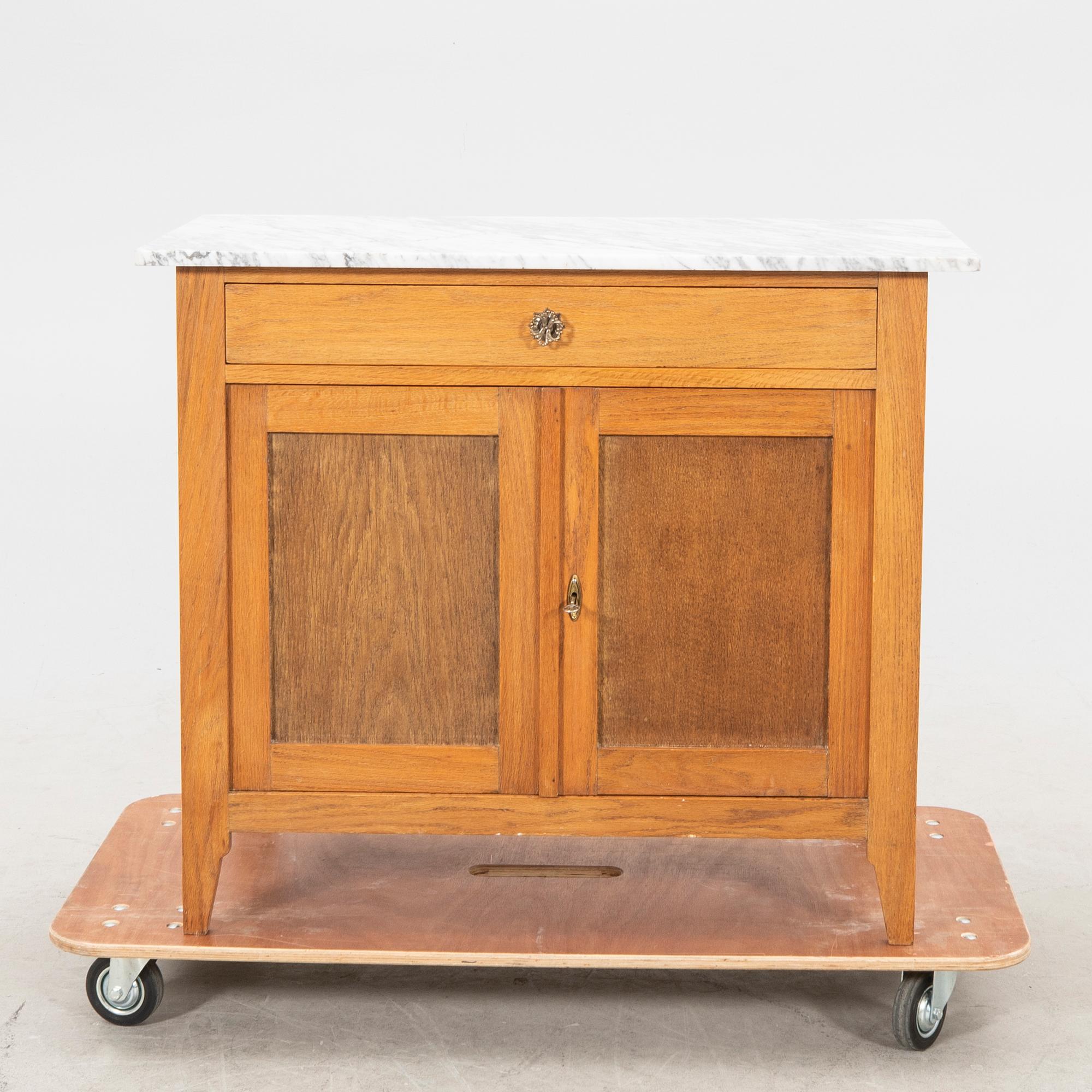 An early 1900s oak and marble cabinet.