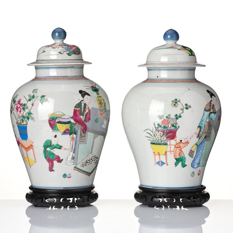 A pair of famille rose 'ladies and boys' vases with covers, late Qing dynasty.