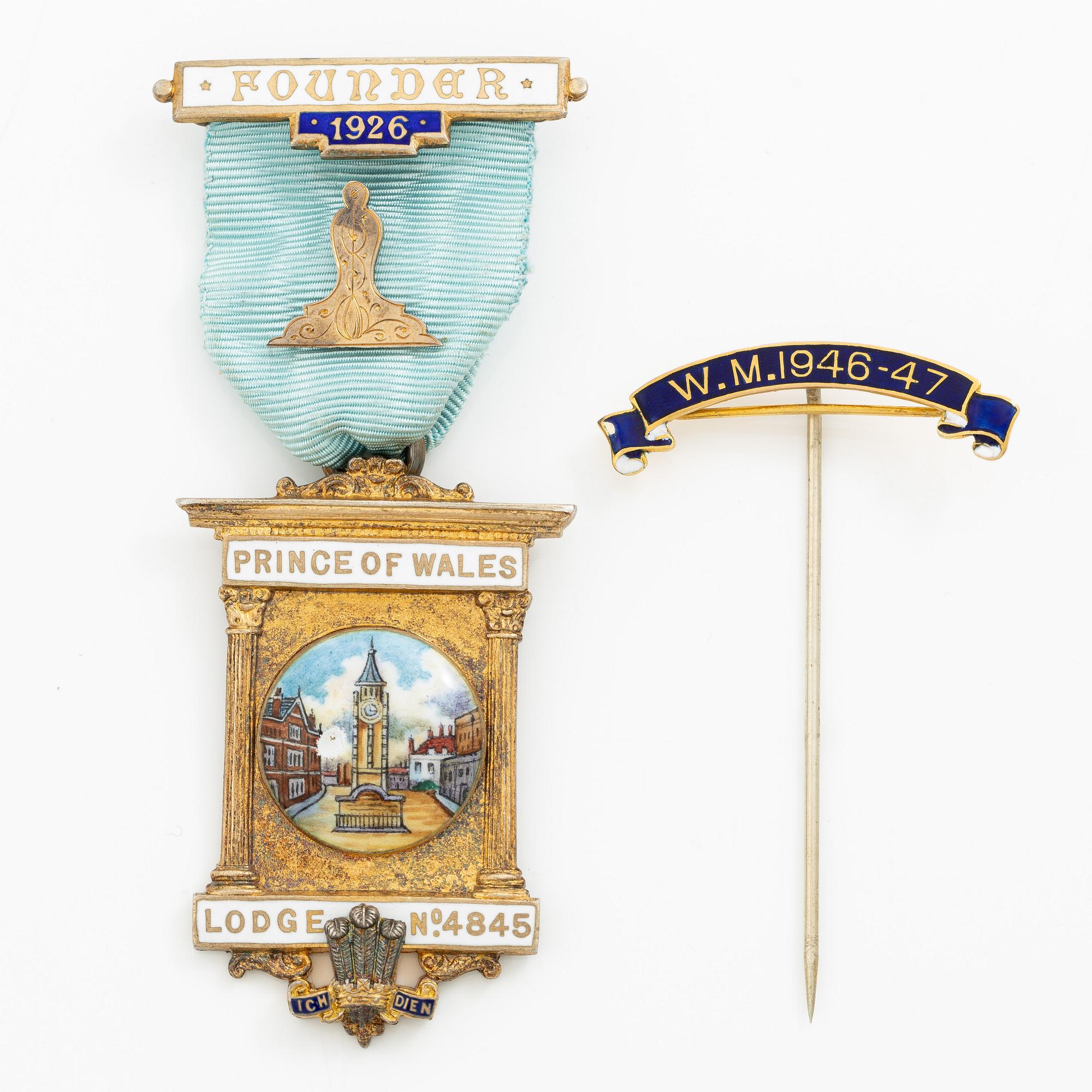 A jeton and pin, in gilded silver and 9 ct gold respectively.