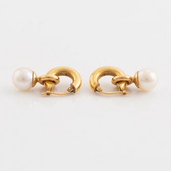 A pair of gold earrings with pearls.