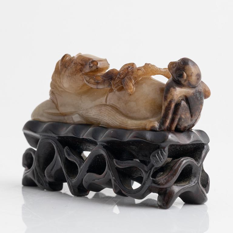 A Chinese sculptured figure of a reclining horse, 20th Century.