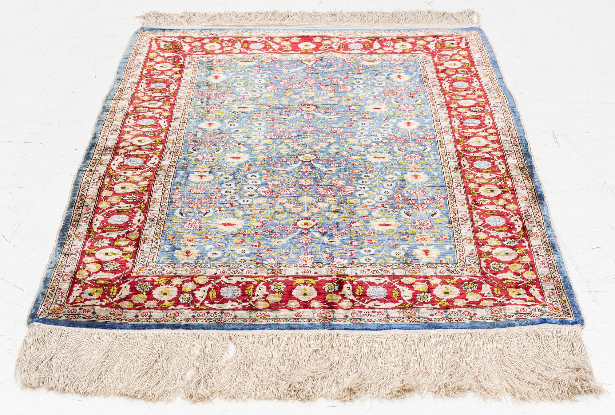 An Oriental silk rug, signed, c. 125 x 85 cm.