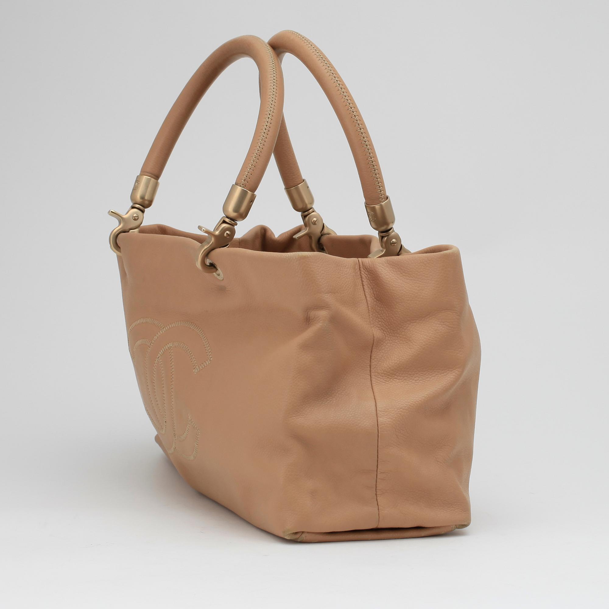 CHANEL, a beige leather handbag.