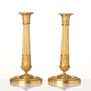 A pair of French Empire ormolu candlesticks, early 19th century.