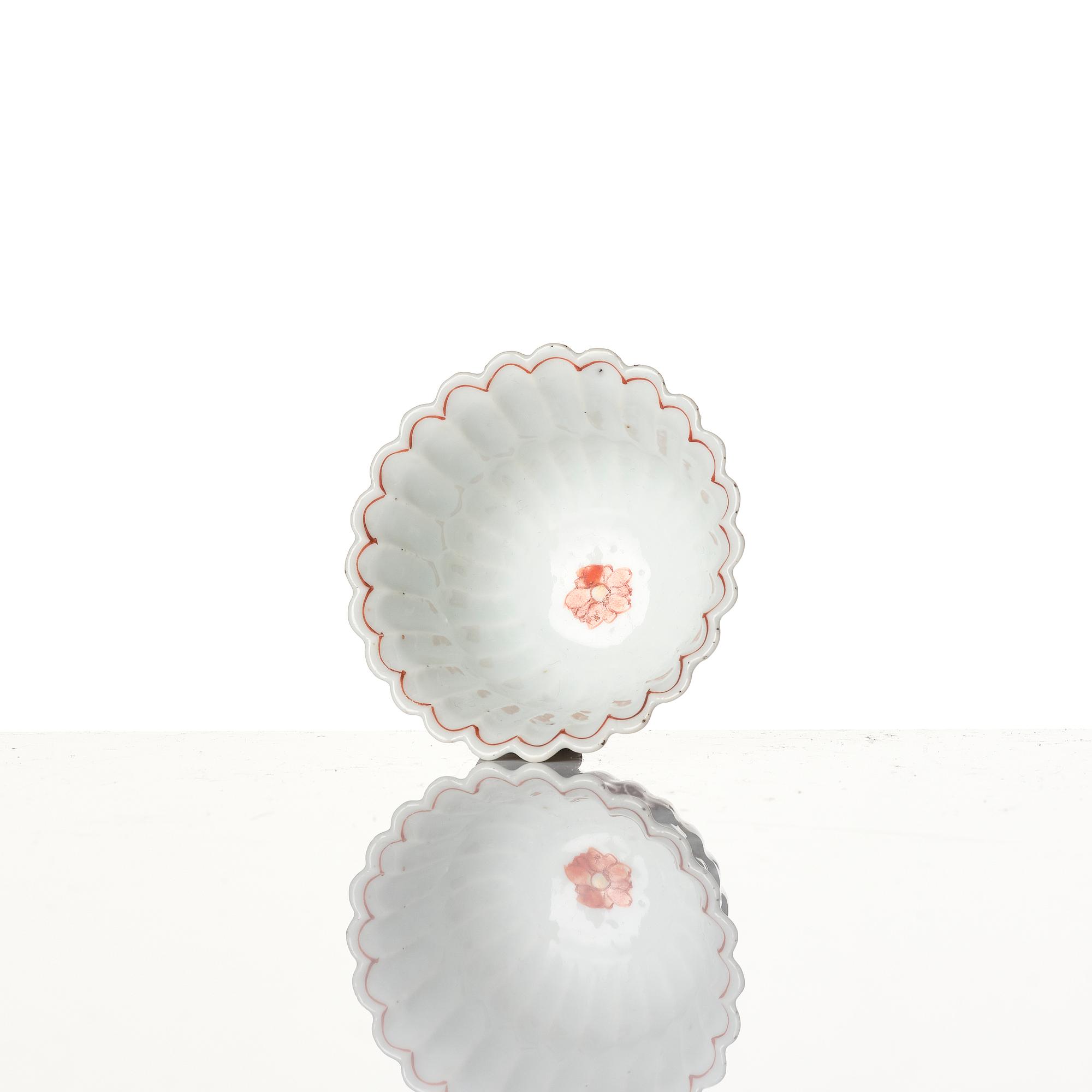 A Chinese iron red porcelain cup with saucer and a small famille verte dish, Qing dynasty, Kangxi (1662-1722).