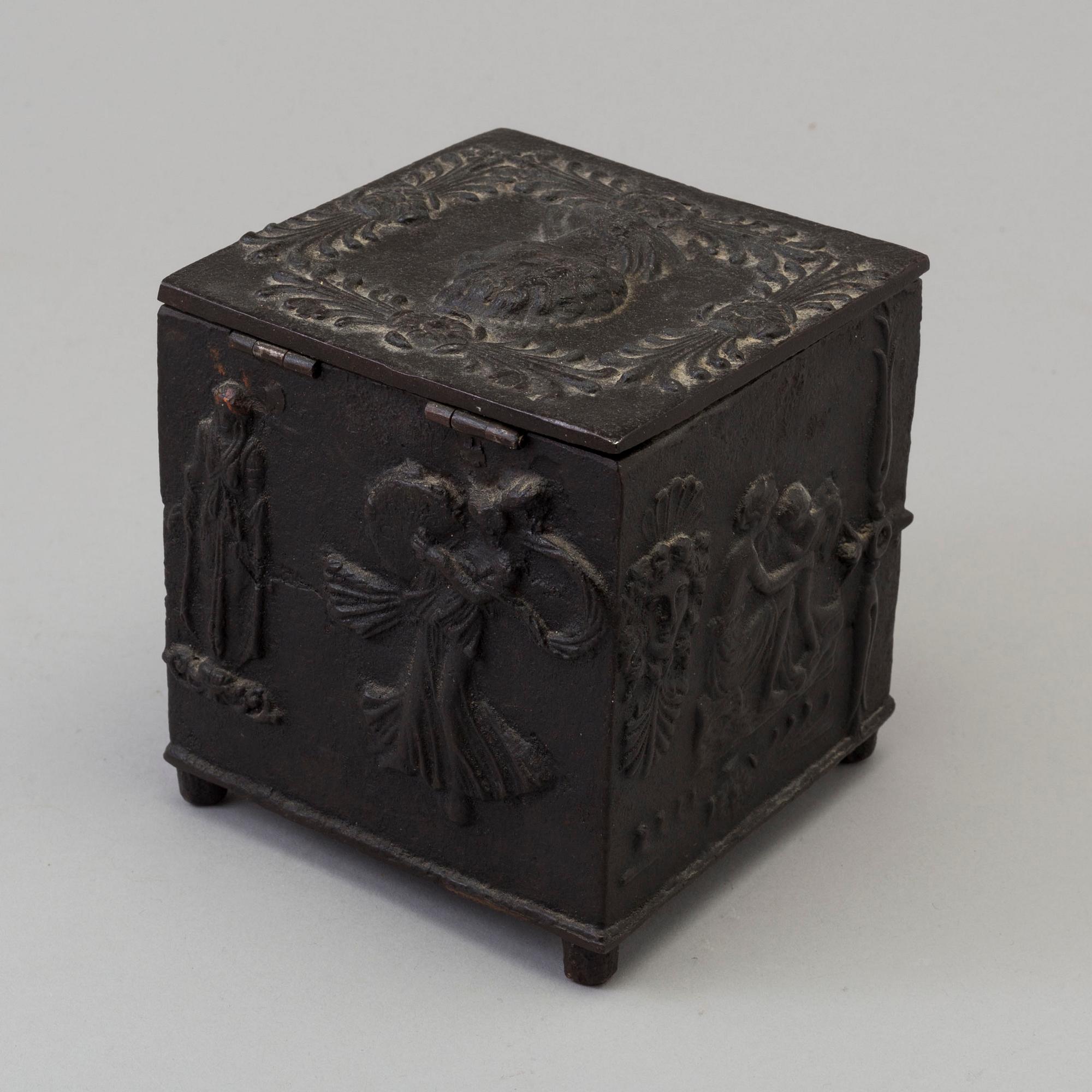 An empire cast iron tobacco box, dated 1838.