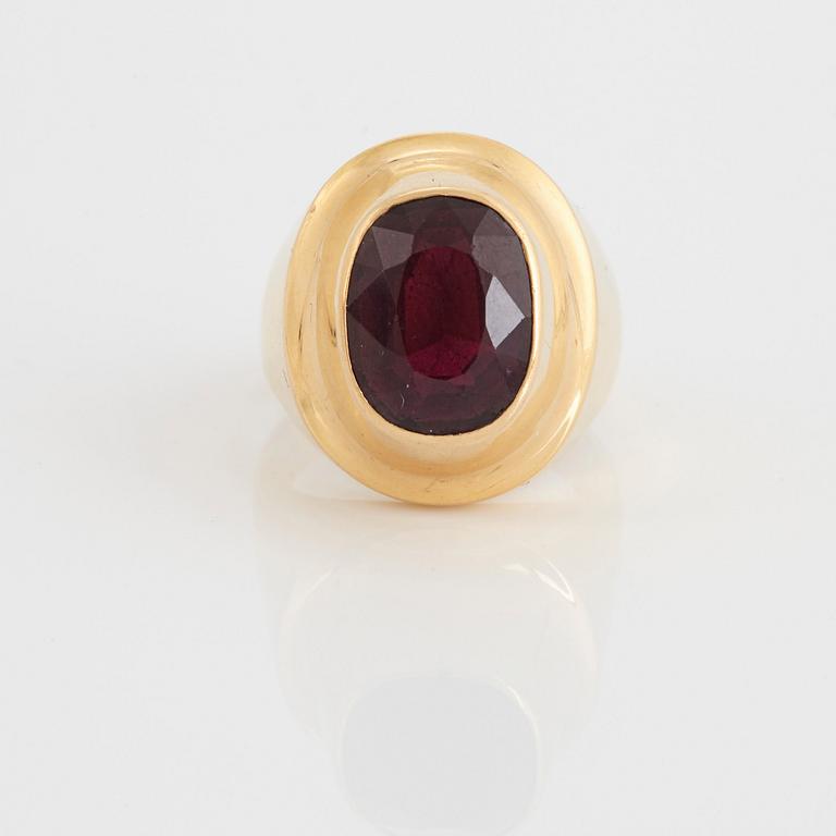 A Sigurd Persson 18K gold ring set with a faceted garnet.