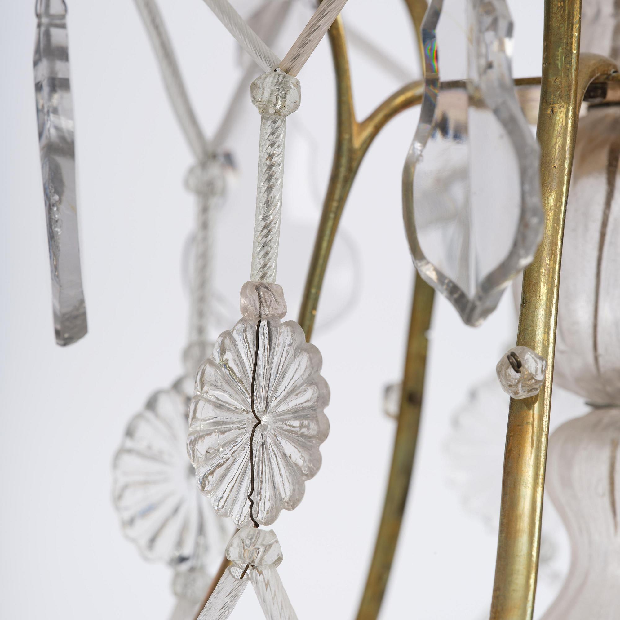 A near pair of rococo-style gilt brass and cut glass six-branch chandeliers, 19th century incorporating older elements.
