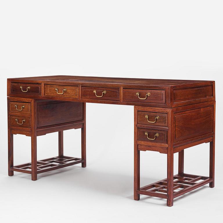 A six-drawer 'jichimu' pedestal partners desk, late Qing dynasty/early 20th century.