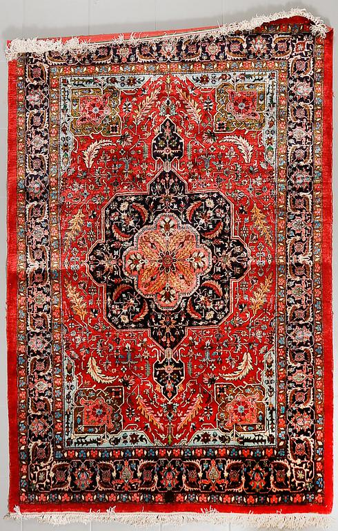An oriental rug, signed, ca 215 x 142 cm.