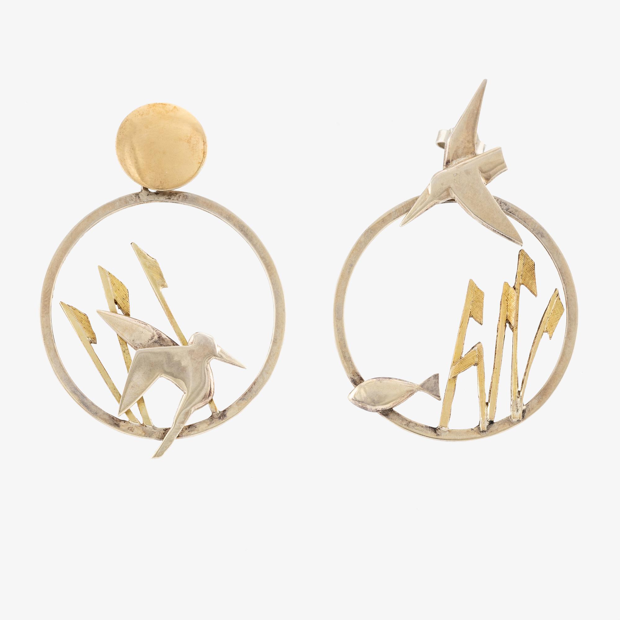 A pair of earrings featuring birds and fish, silver with gold detail.