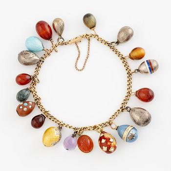 Bracelet with charms in the shape of eggs, the bracelet is 14K gold and 13 loose charms in the shape of eggs.