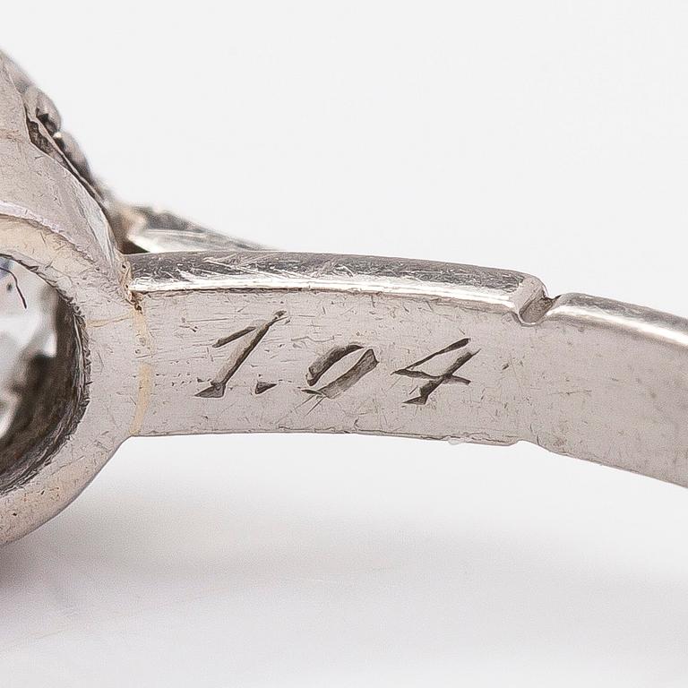 Sormus, platinaa, briljanttihiottu timantti 1.04 ct kaiverruksen mukaan. J.A Tarkiainen, Helsinki. Todistuksella.