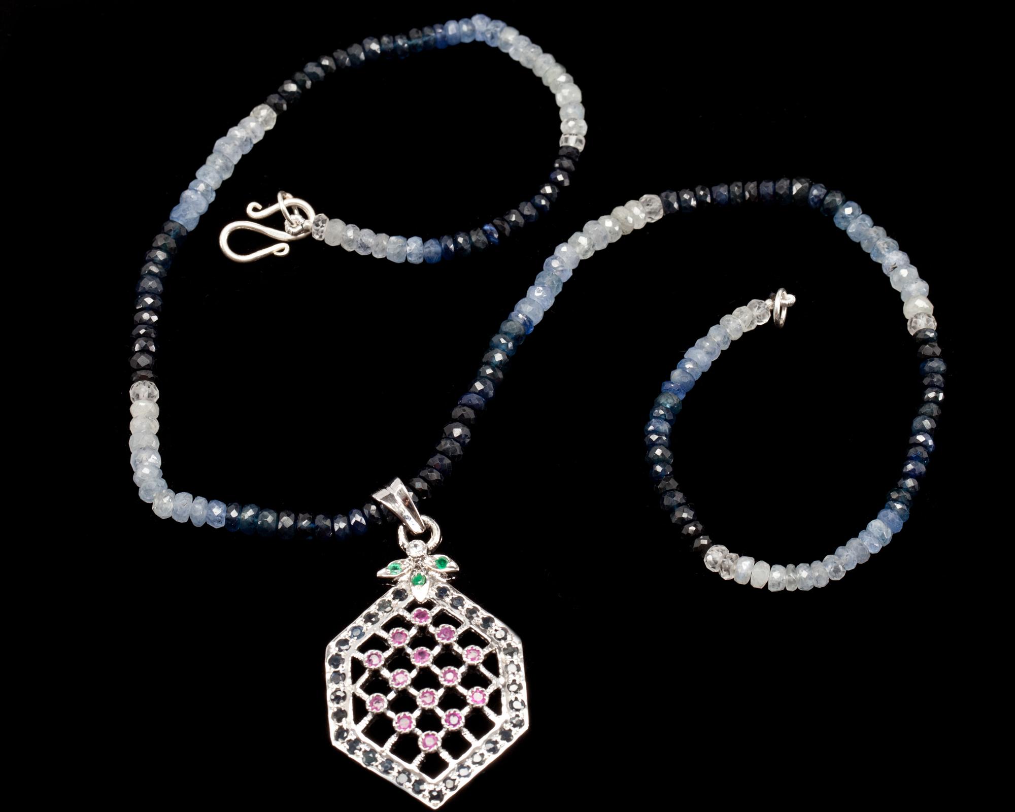 COLLIER MED HÄNGE, fasettslipade svarta och grå stenar, hänge besatt med bl.a. rubiner och smaragder.