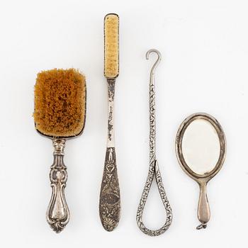 Two brushes, a hook, and a small mirror, silver and nickel silver.