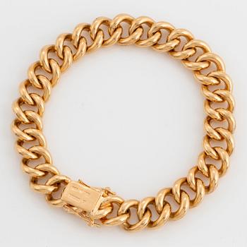 An 18K gold curb link bracelet.