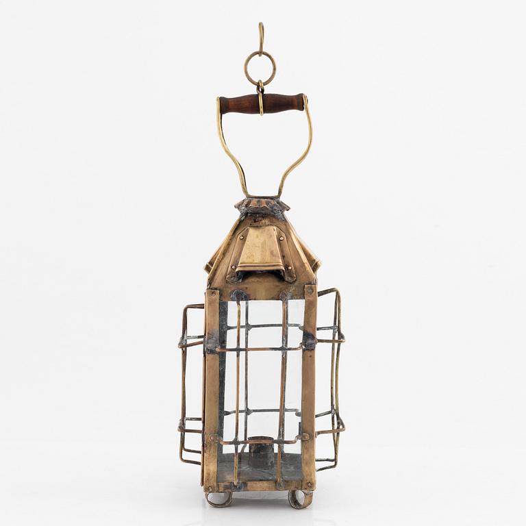 A metal storm lantern, marked A.T, circa 1900.