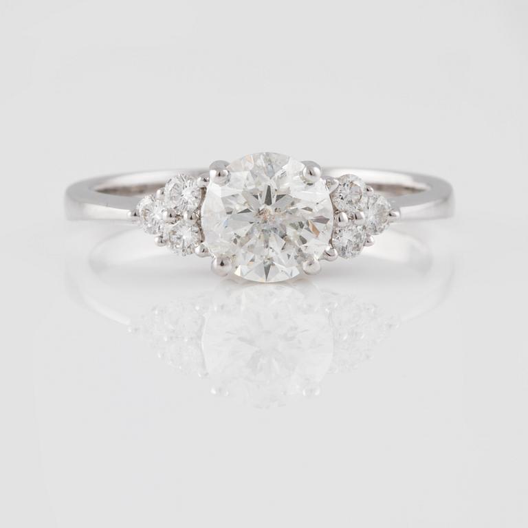 RING, 18K vitguld med briljantslipad diamant ca 0.97 ct och små briljantslipade diamanter ca 0.16 ct. Vikt 2,6 gram.